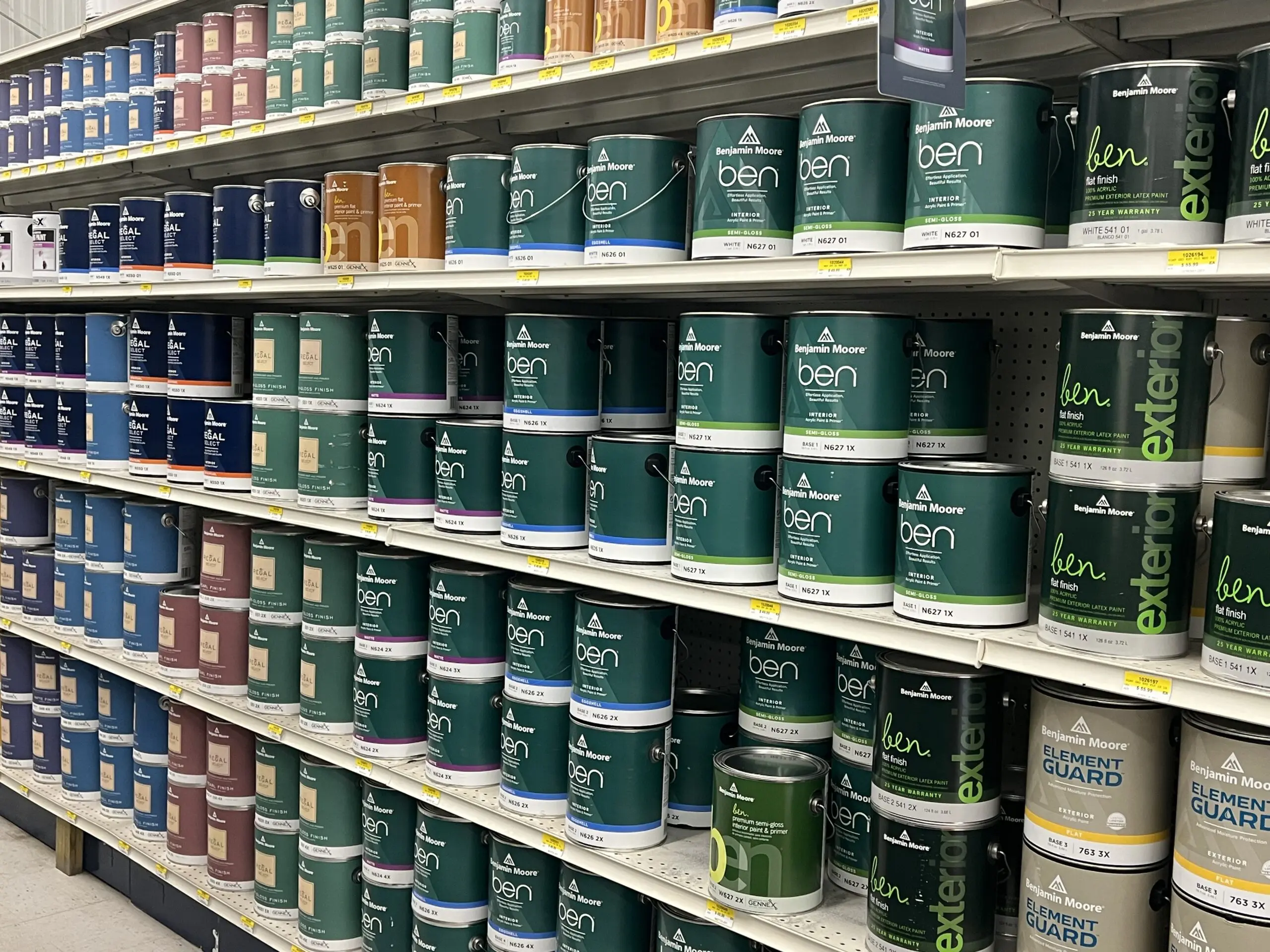 A shelf filled with lots of paint cans.