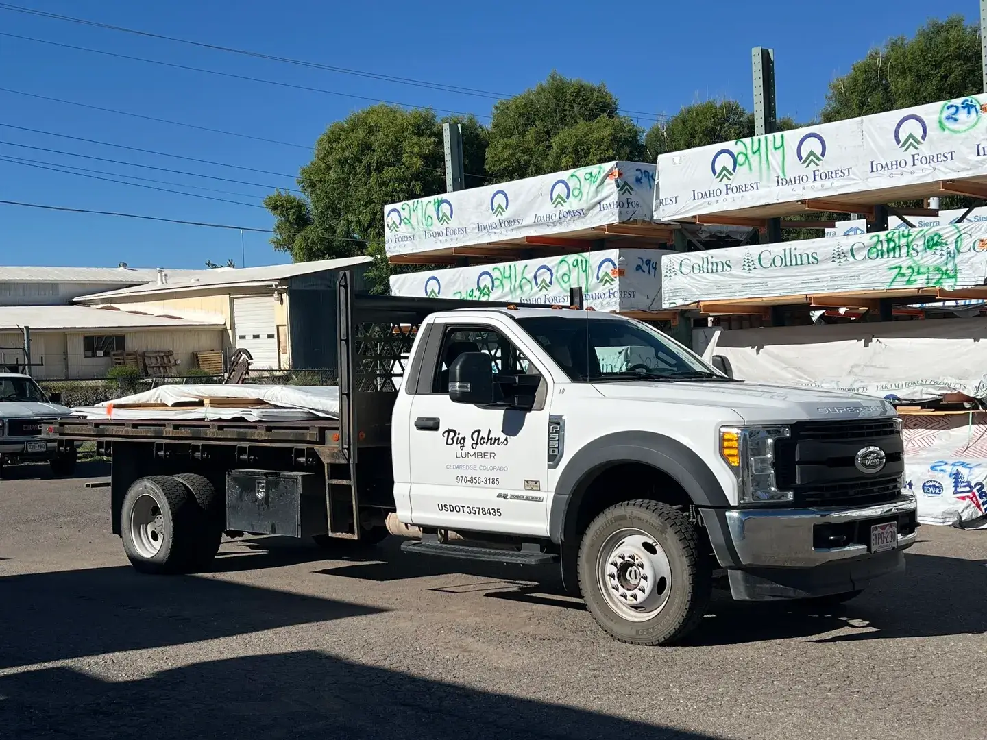 A white flatbed truck parked in the street.